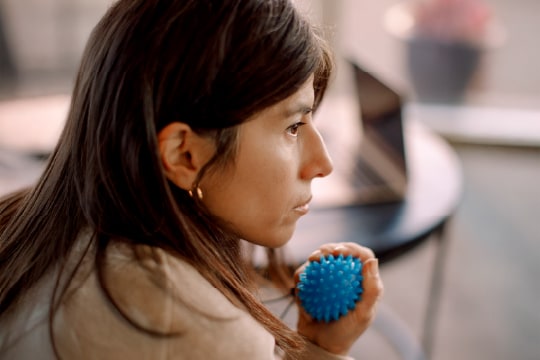 Woman gazes pensively into the distance while squeezing a stress ball.